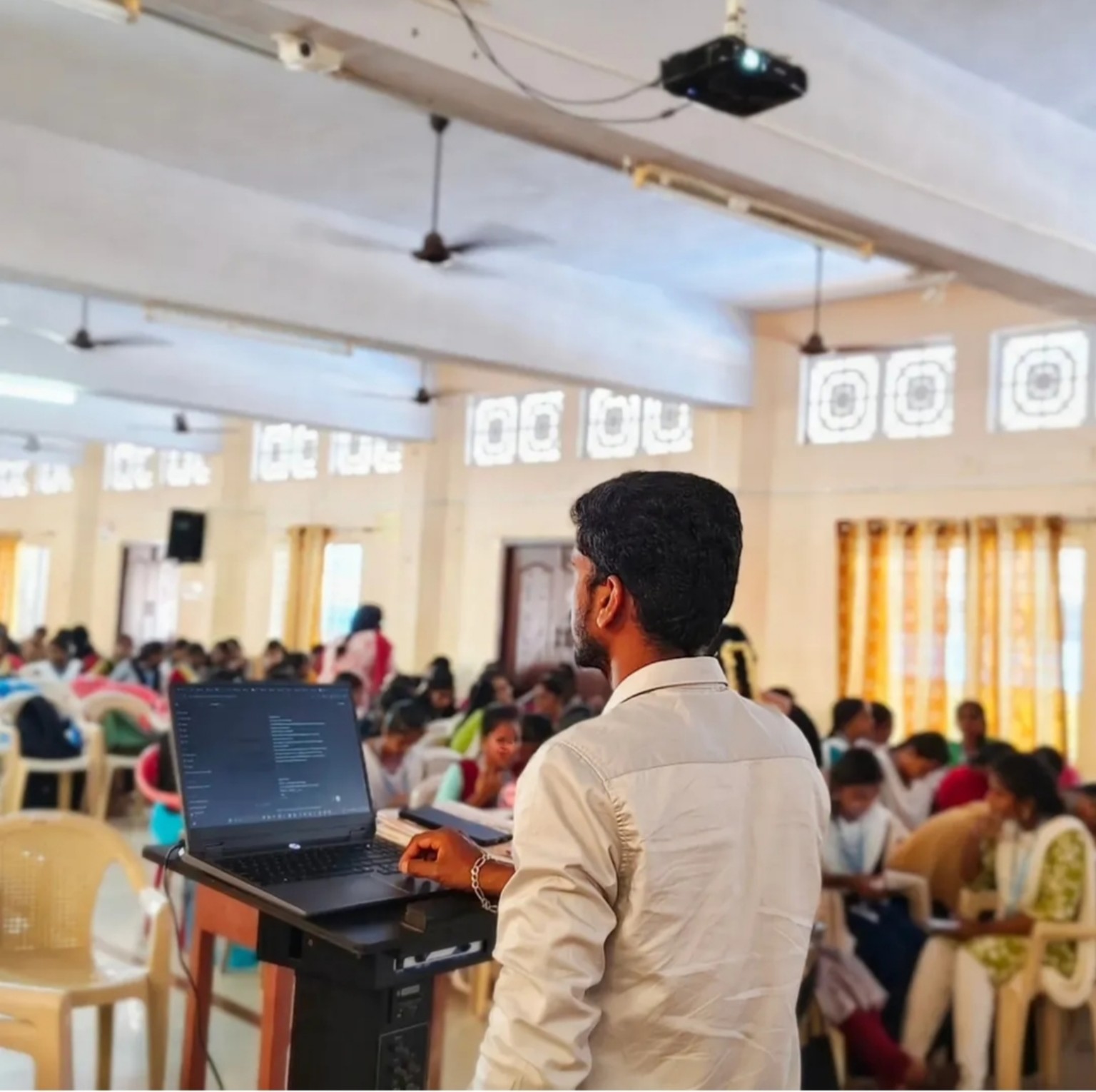 Codexaon trainer leading a large classroom workshop with a laptop